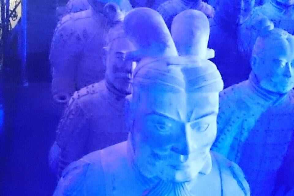 Eine Sammlung von Statuen in bläulichem Licht.