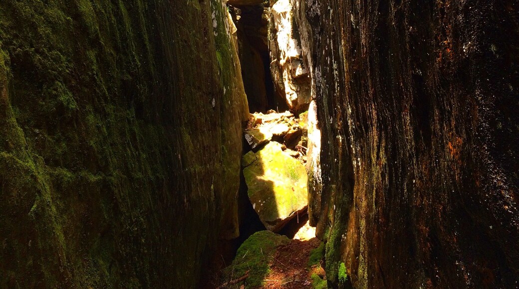 Giant crack in the ground leading into a cave