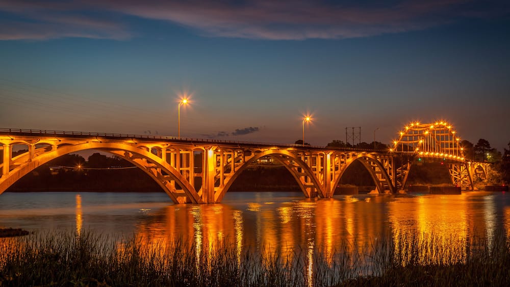 The bridge over the Arkansas River at Ozark Arkansas at dusk with the lights on