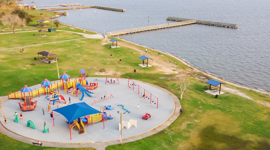 A playground with slides and swings by a lake.