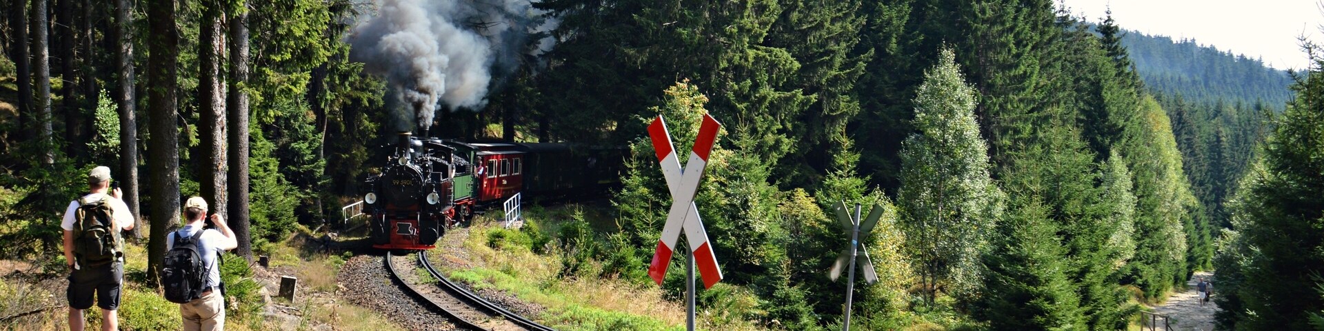 Der HSB-Traditionszug in Höhe der Alten Bobbahn auf dem Weg zum Brocken. Die Brockenbahn ist eine hauptsĂ€chlich touristisch genutzte, meterspurige Schmalspurbahn der Harzer Schmalspurbahnen (HSB). Sie fĂŒhrt von Drei Annen Hohne an der Harzquerbahn ĂŒber Schierke zum Brocken. The Brocken Railway (German: Brockenbahn) is one of three tourist metre gauge railways which together with the Harz Railway and Selke Valley Railway form the Harz Narrow Gauge Railways railway network in the Harz mountain range of Germany. It runs from the station of Drei Annen Hohne at 542 m (1,778 ft), where it joins the Harz Railway, via Schierke and the Bode River valley to the summit of the Brocken, the highest mountain of the Harz at 1,141 m (3,743 ft) and part of the Harz National Park.