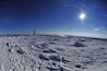 A snowy landscape with a tower and a clear blue sky.