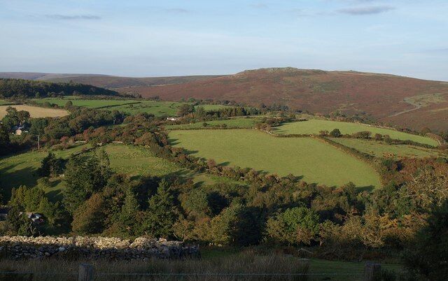 Fields near Huccaby Looking across the West Dart valley from the lane from Hexworthy to Holne. The main visible buildings are Huccaby House (left) and some outbuildings at Huccaby Farm. On the horizon is Yar Tor.