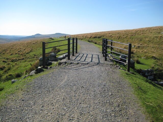 Princetown: Former Yelverton to Princetown railway This is the trackbed of the former Yelverton to Princetown railway that opened in 1883 and closed in 1956. Here the railway traverses the slopes of North Hessary Tor, passing over a gully at the head of the River Meavy by means of this bridge 1011992. The trackbed here now forms a section of the long distance footpath of the Dartmoor Way. The distant tors visible are Leather Tor to the left and Sharpitor to the right, in SX5670 and SX5570 respectively.