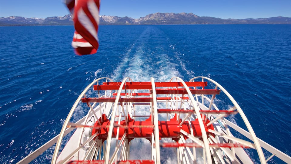 A boat on a calm sea with mountains in the background.