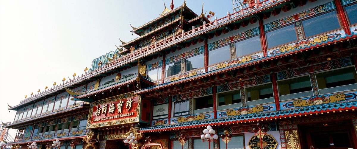 A traditional multi-story building with ornate decorations and signage in a foreign language.