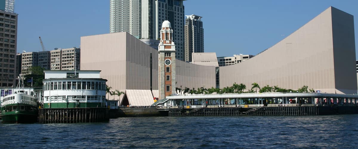Tsim Sha Tsui from Victoria Harbour - Hong Kong. Iconic clocktower - ferry terminal and Hong Kong cultural center