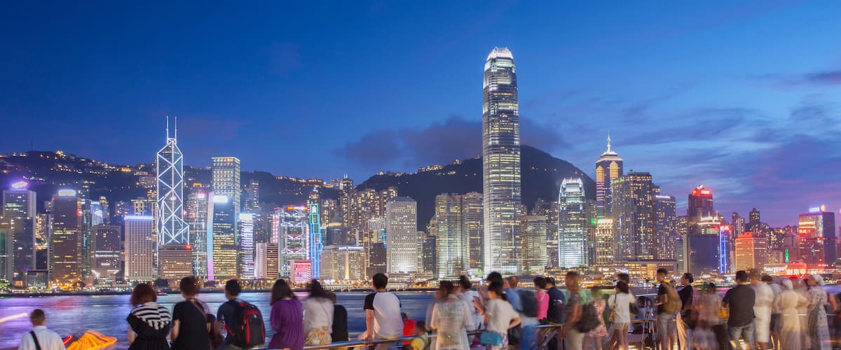 E5PH09 Tourists looking at Hong Kong Island skyline from Tsim Sha Tsui at dusk, Hong Kong, China, Asia