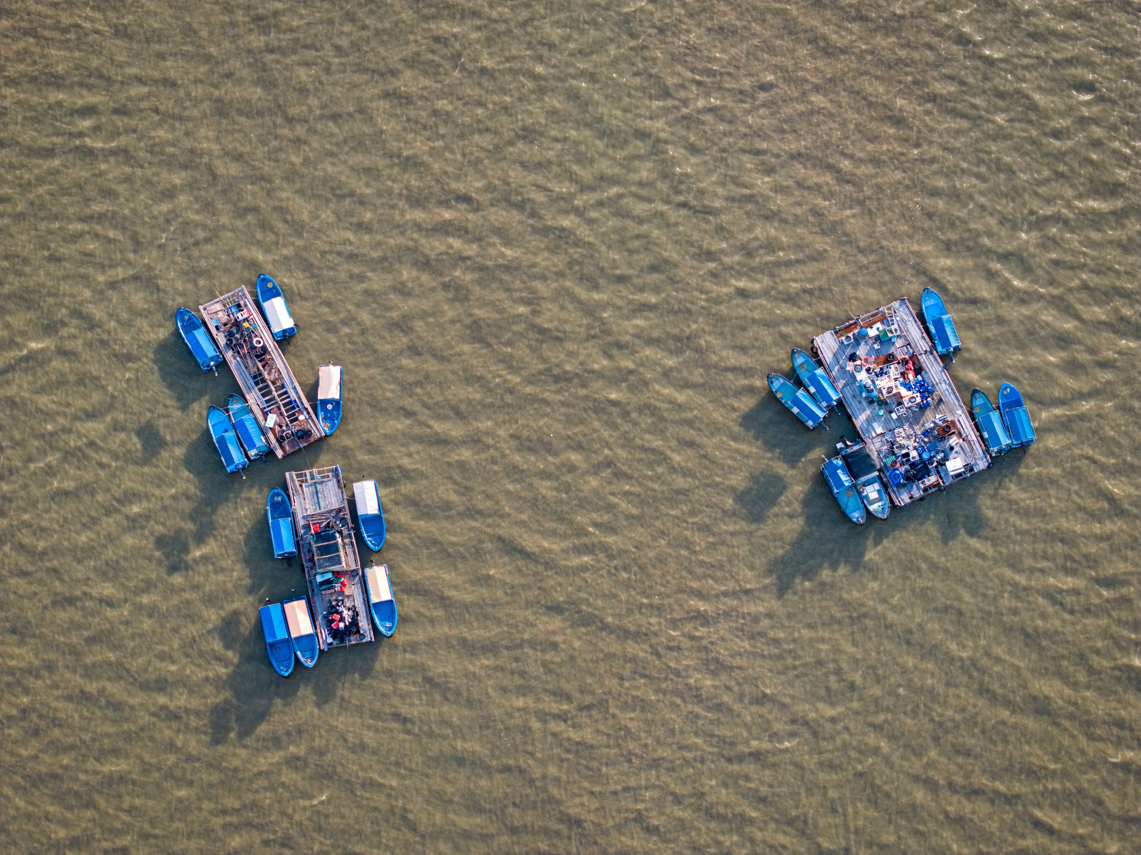 Duas plataformas flutuantes com barcos e espaços para sentar.