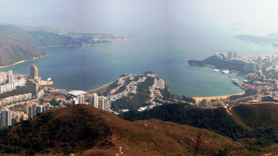 A coastal city with high-rise buildings, a bay, and hilly terrain.