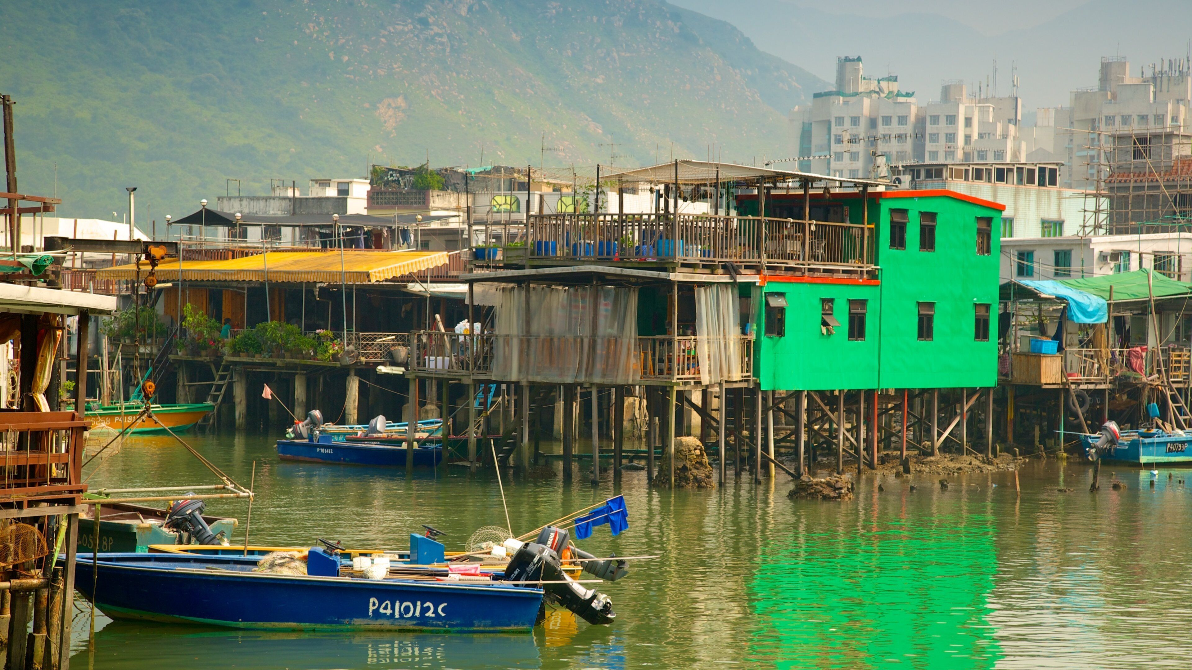 Tai O Village som inkluderer hus, båter og elv eller bekk