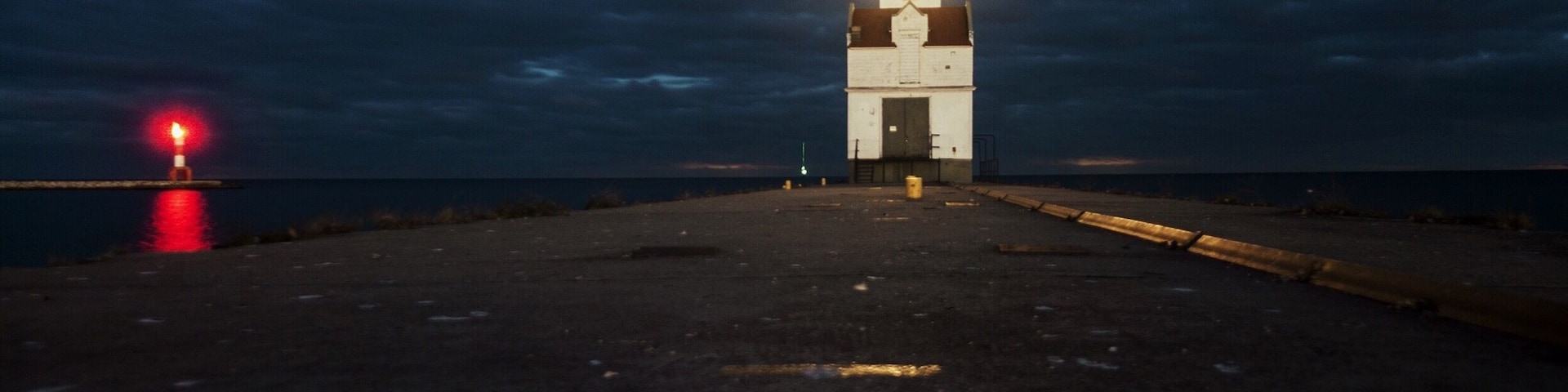I took this on the pier about a hour after sunset. 
The Kewaunee Lighthouse represents the maritime heritage of the harbor while continuing to serve as a navigational beacon to Lake Michigan boating traffic.  The property's period of historic significance begins in 1931 when it was established as a lighthouse and ends in 1959, the most recent year of its operation 50 years before the present. 
The lighthouse personifies early twentieth century lighthouse architecture and engineering.  It exemplifies design and construction methods used in building lighthouses and fog signal buildings on piers during that time period. This structure possesses its original location, setting and design, and embodies historical qualities of integrity in materials, workmanship, feeling and association. The lighthouse lantern room houses a historic fifth order Fresnel lens with an electric light that is currently used by the USCG as a navigational aid.  The character and appearance of Kewaunee Pierhead light are largely unchanged from when it was established as an aid to navigation.