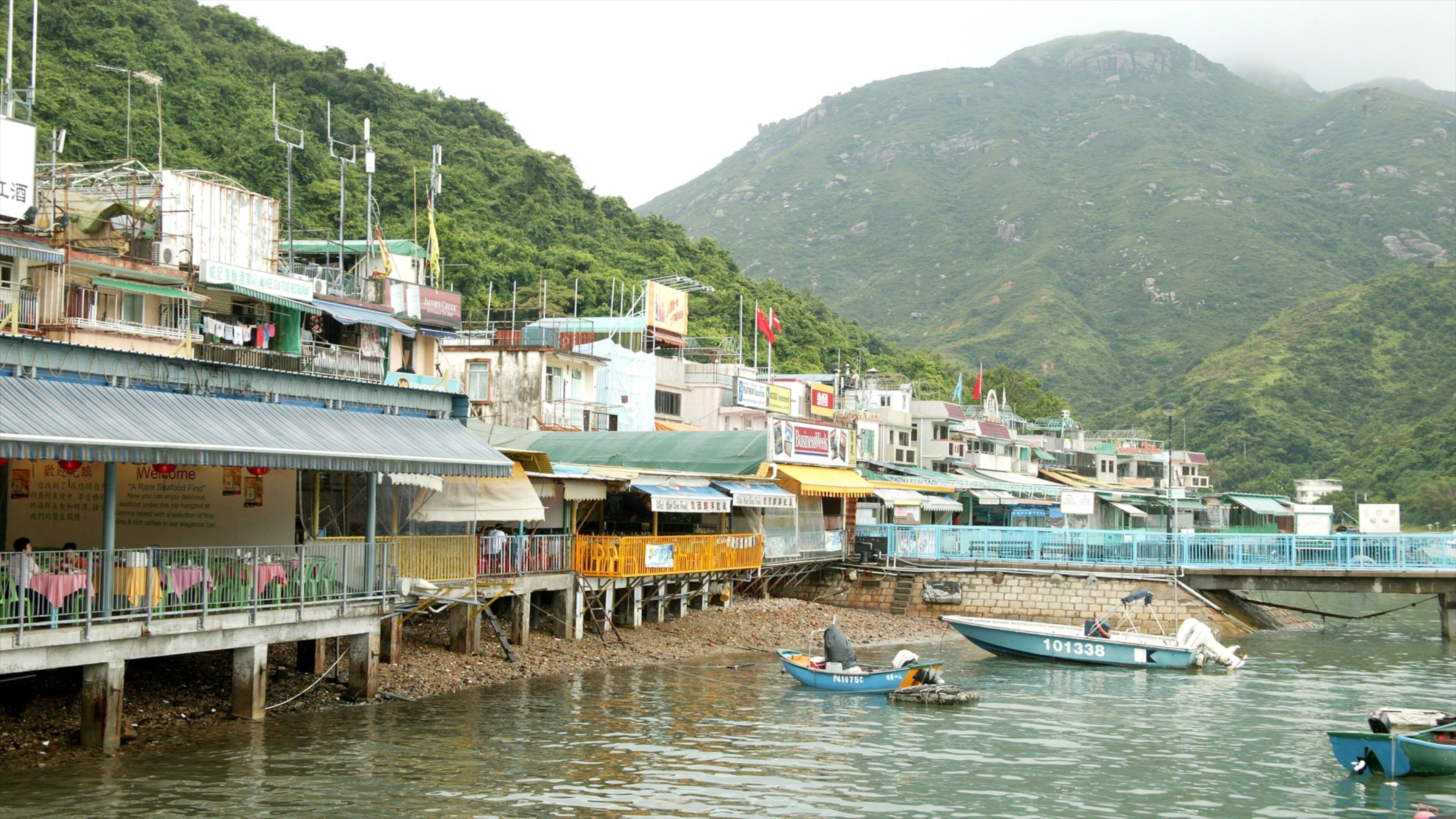 Lamma Island featuring a coastal town, boating and mountains