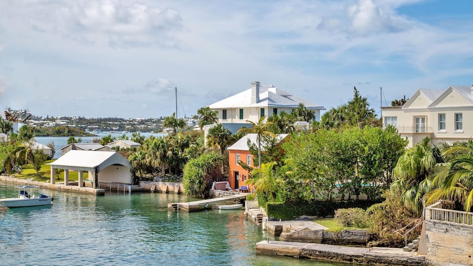 A waterfront with houses, a dock, and a boat.