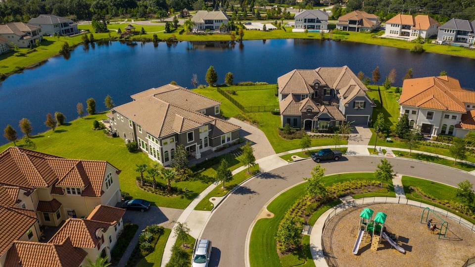 A residential area with houses, a lake, and a playground.