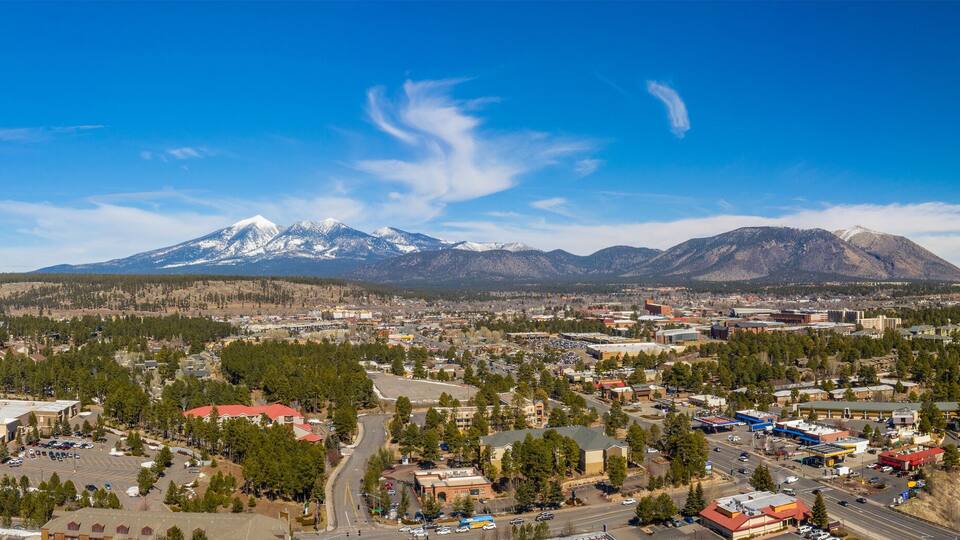 A town with a prominent snow-capped mountain in the background.