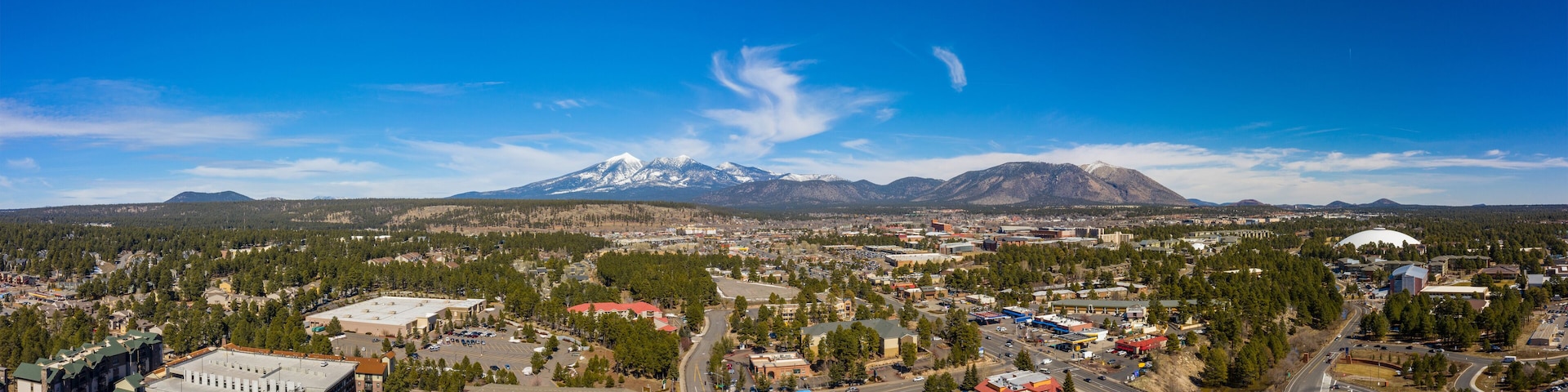 A town with a prominent snow-capped mountain in the background.