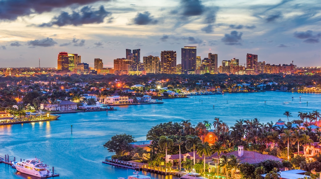 A city skyline at dusk with a harbor and boats.