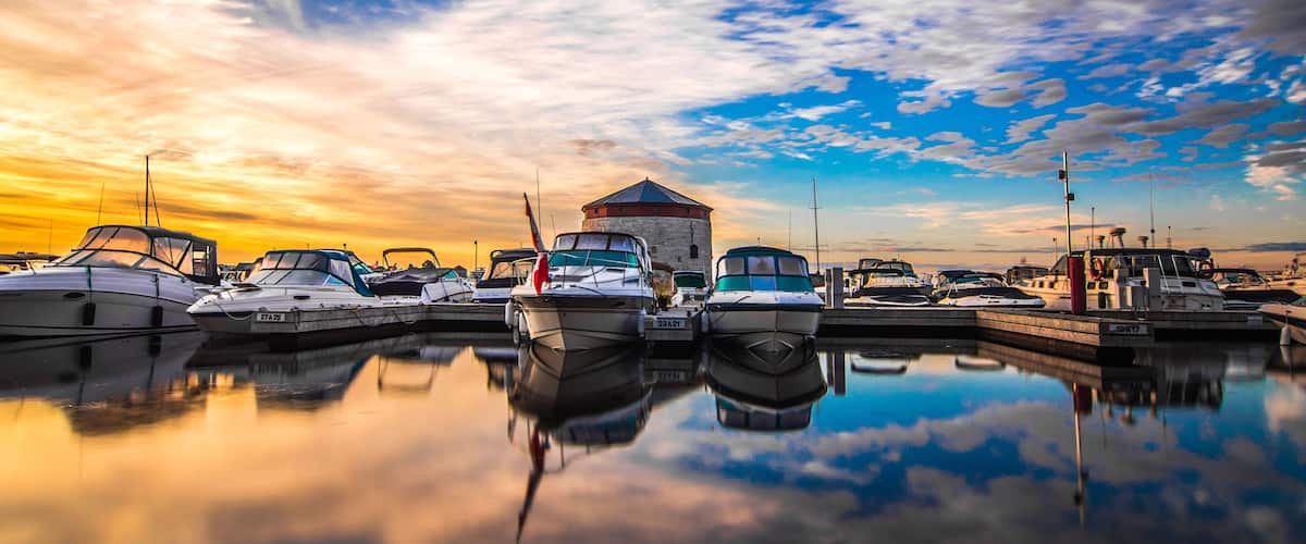A marina with boats docked at sunset.