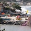 A beach with boats, umbrellas, and people.