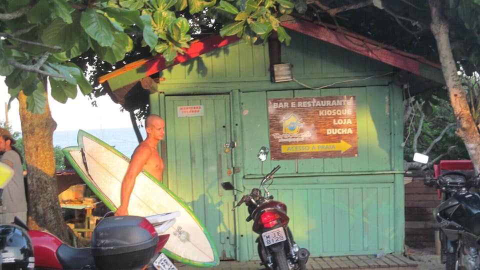 Een groen gebouw met een bord waarop staat: BAR E RESTAURANTE KIOSQUE LOJA DUCHA ACESSO A PRAIA.