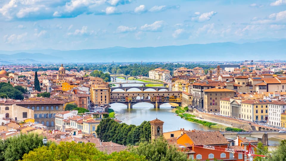 A cityscape with a river, a prominent bridge, and surrounding buildings.
