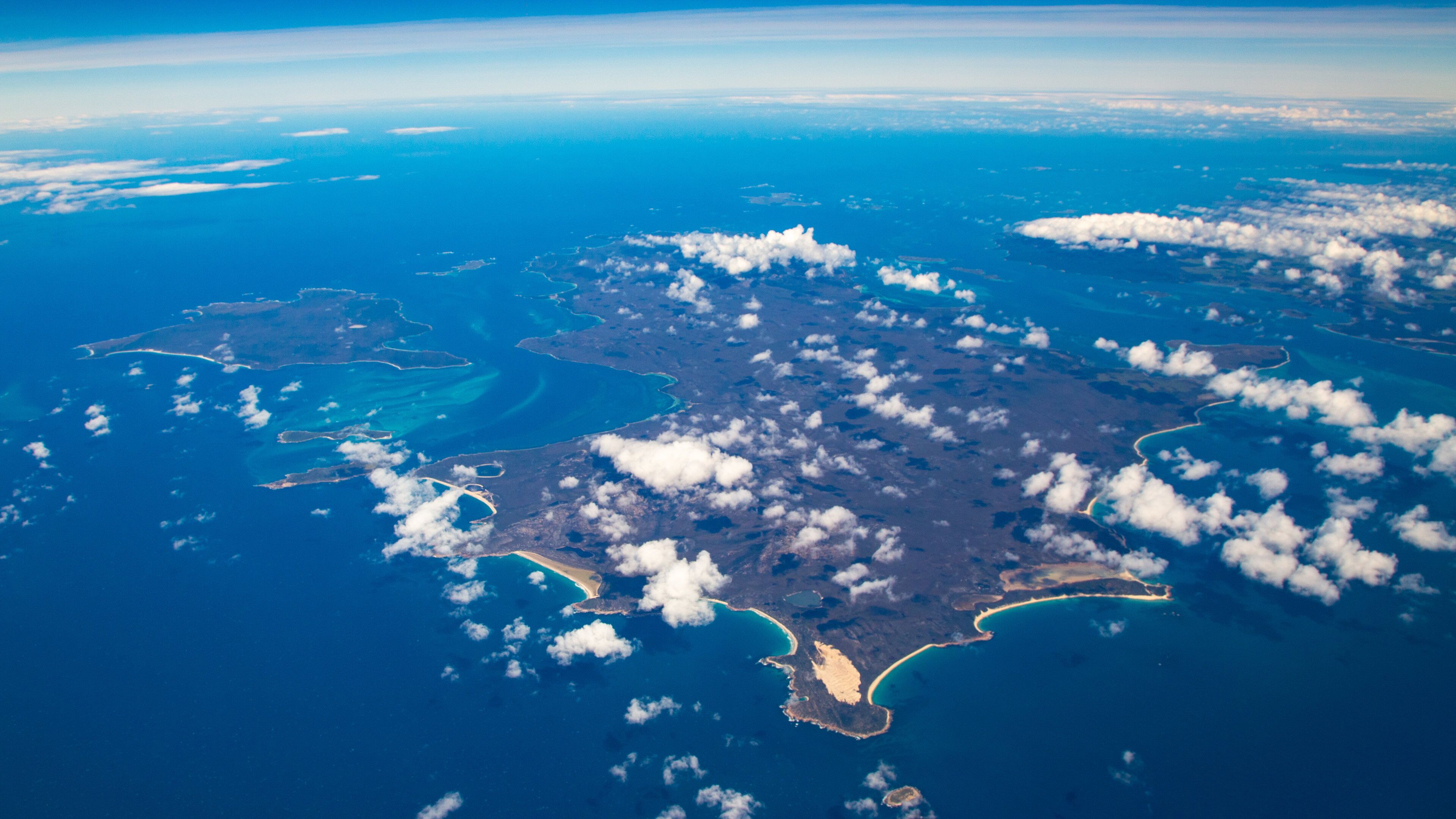 An aerial view of a large island with multiple inlets and a coastline.