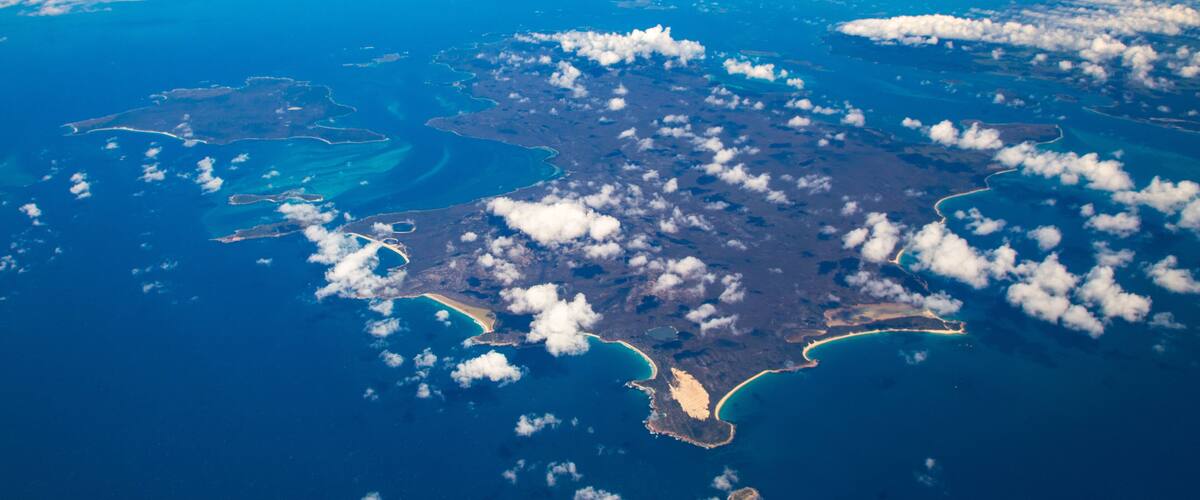 An aerial view of a large island with multiple inlets and a coastline.