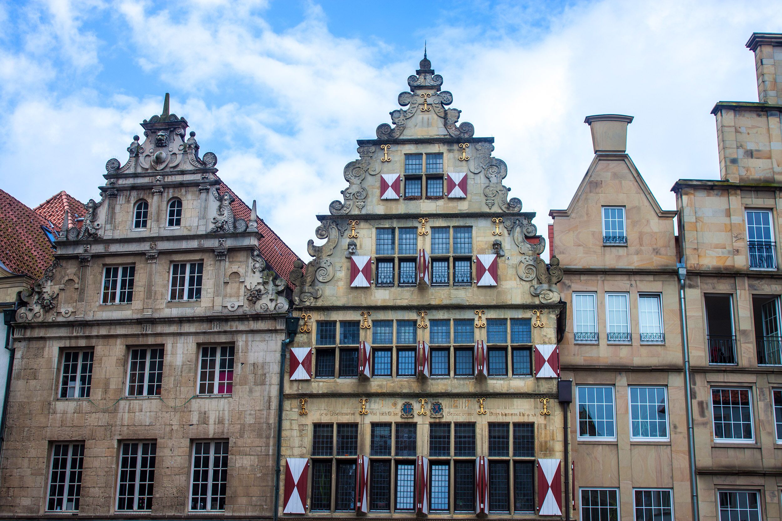 Un edificio histórico con detalles arquitectónicos ornamentales, incluyendo un tejado a dos aguas y elementos decorativos.