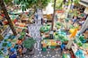 An outdoor market with various stalls selling fruits, vegetables, and other produce.