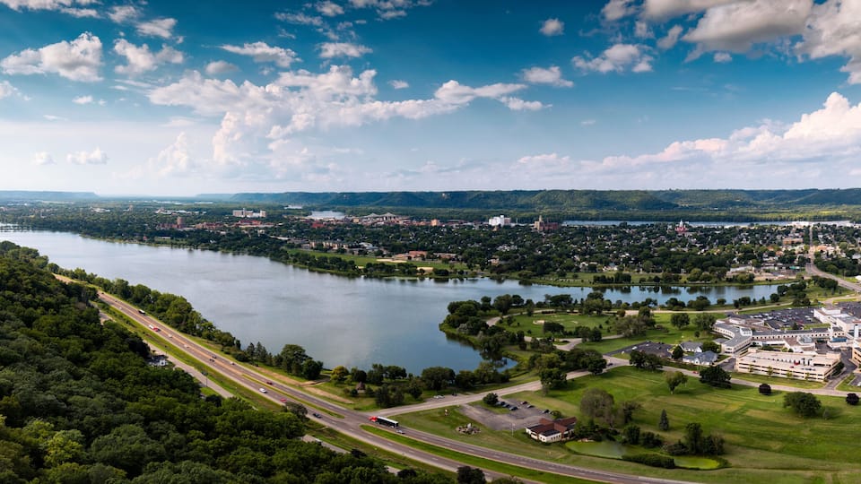 A river, highway, and urban area with buildings and greenery.