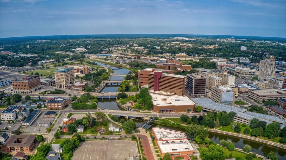 An aerial view of a city with a river, bridges, and various buildings.