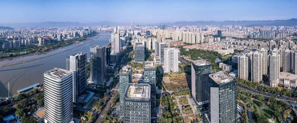 A cityscape with a river, high-rise buildings, and a bridge.