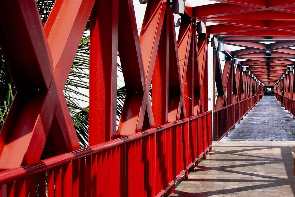 A red metal bridge with a patterned walkway.
