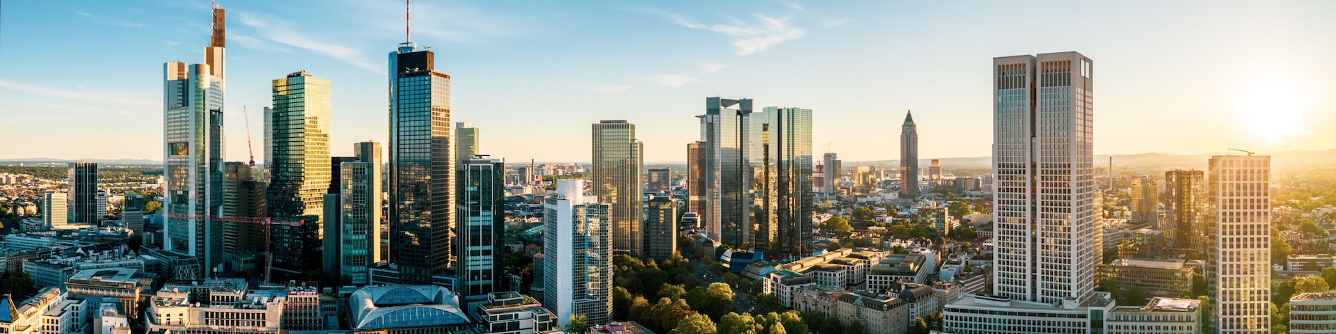 A cityscape with modern skyscrapers, a mix of older buildings, and a clear sky.
