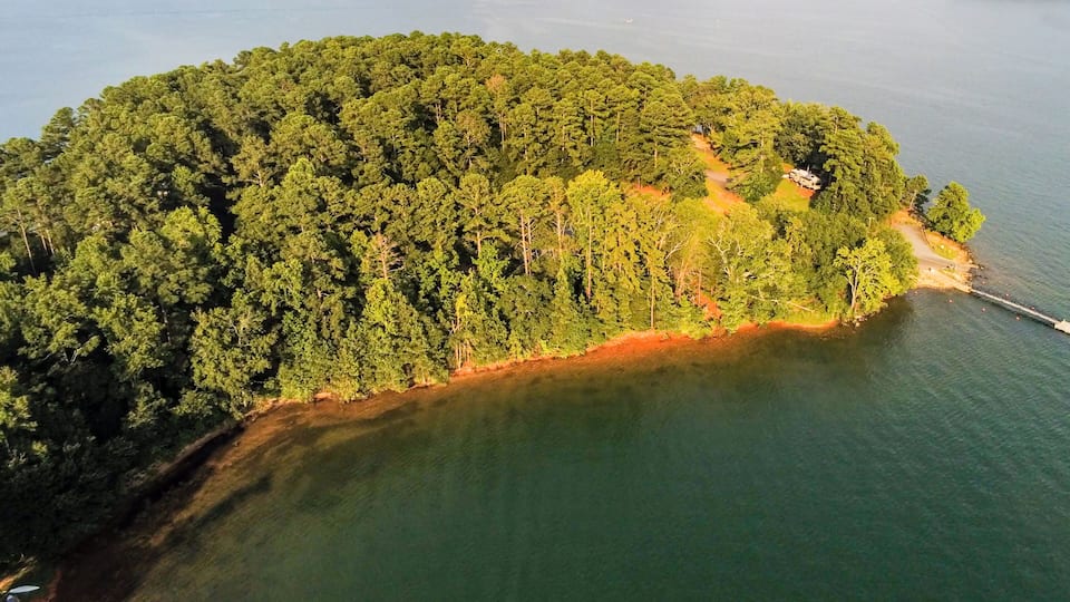 An aerial view of a forested island surrounded by water.