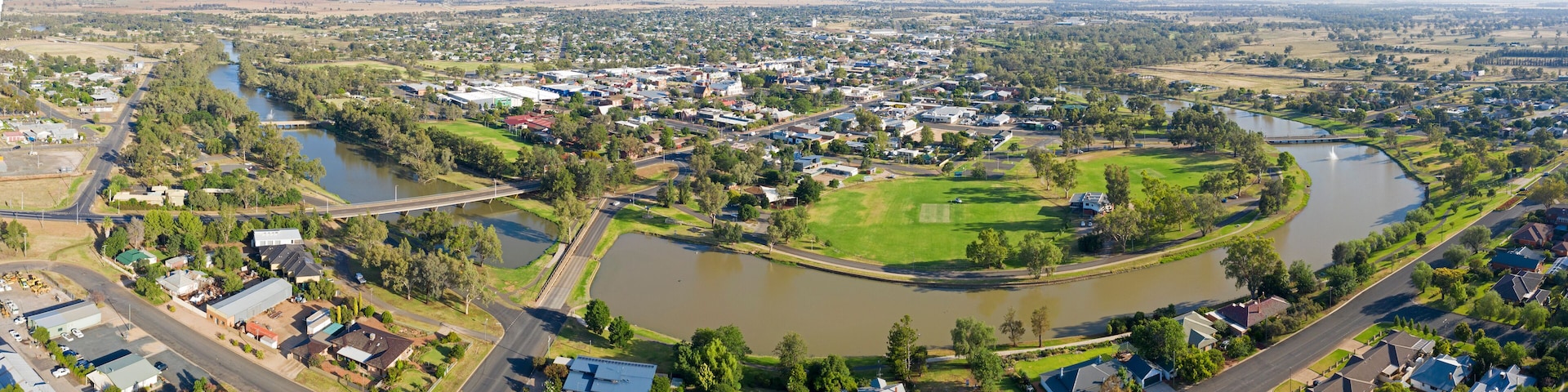 A town with a river, green spaces, and a golf course.
