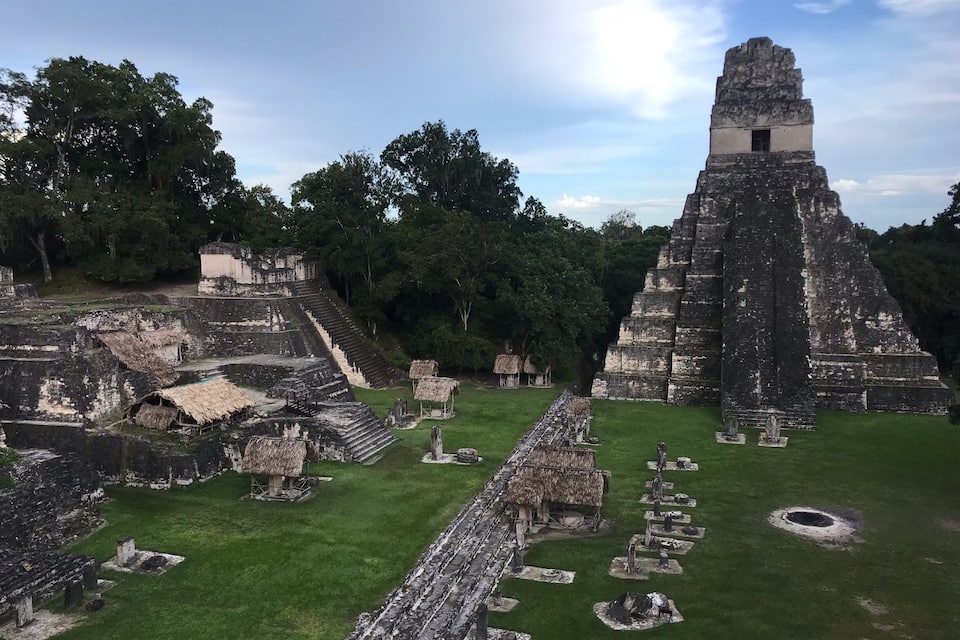 Antiguas ruinas mayas con una gran pirámide y estructuras escalonadas.
