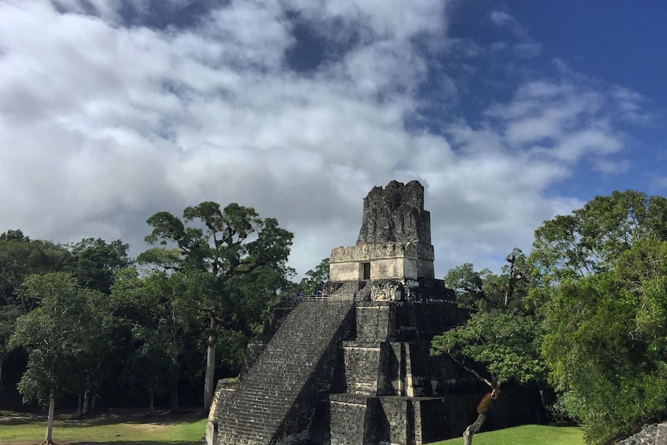 A large pyramid structure surrounded by lush greenery.