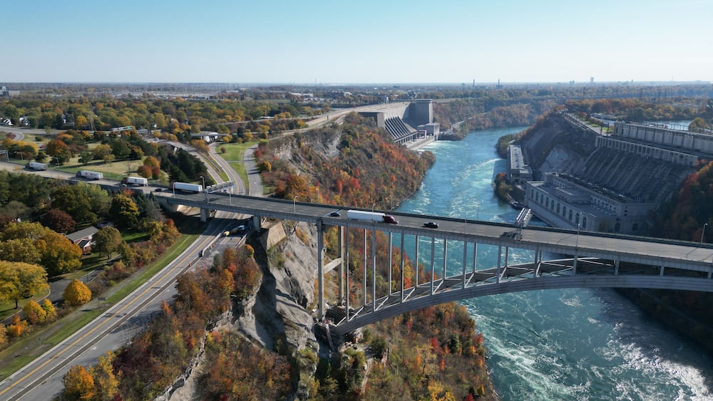 Aerial over the Niagara River and gorge, the international border crossing Queenston-Lewiston bridge between New York, United States and Ontario, Canada with hydroelectrical power plants, in autumn.