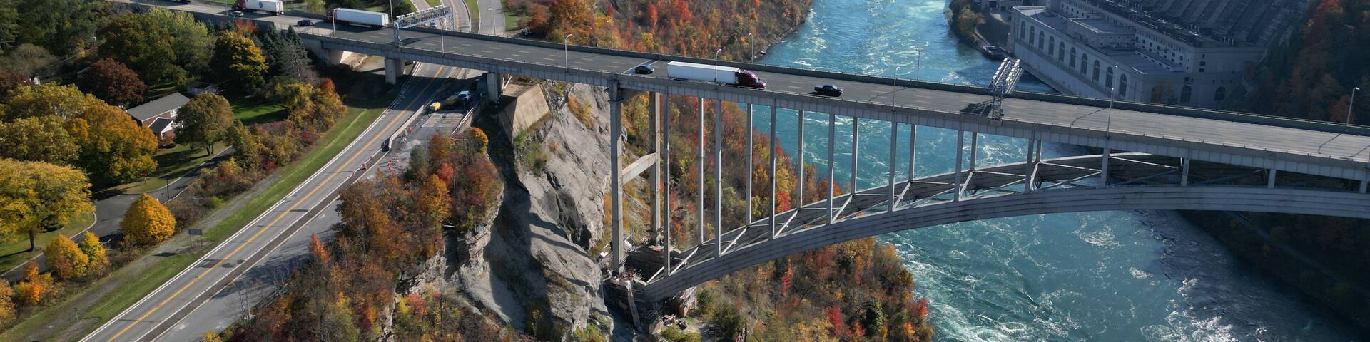 Aerial over the Niagara River and gorge, the international border crossing Queenston-Lewiston bridge between New York, United States and Ontario, Canada with hydroelectrical power plants, in autumn.