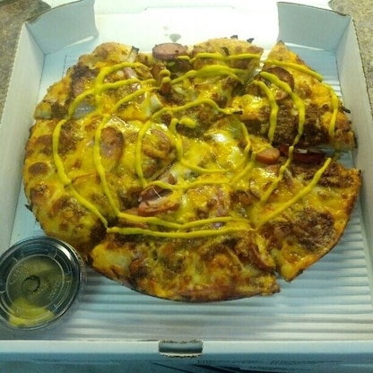 The Tony Packo's pizza made with Tony Packo's Hot Dog Sauce, sliced Tony Packo's Hungarian Sausage, red onions, cheddar and mozzarella cheeses, and topped with mustard.