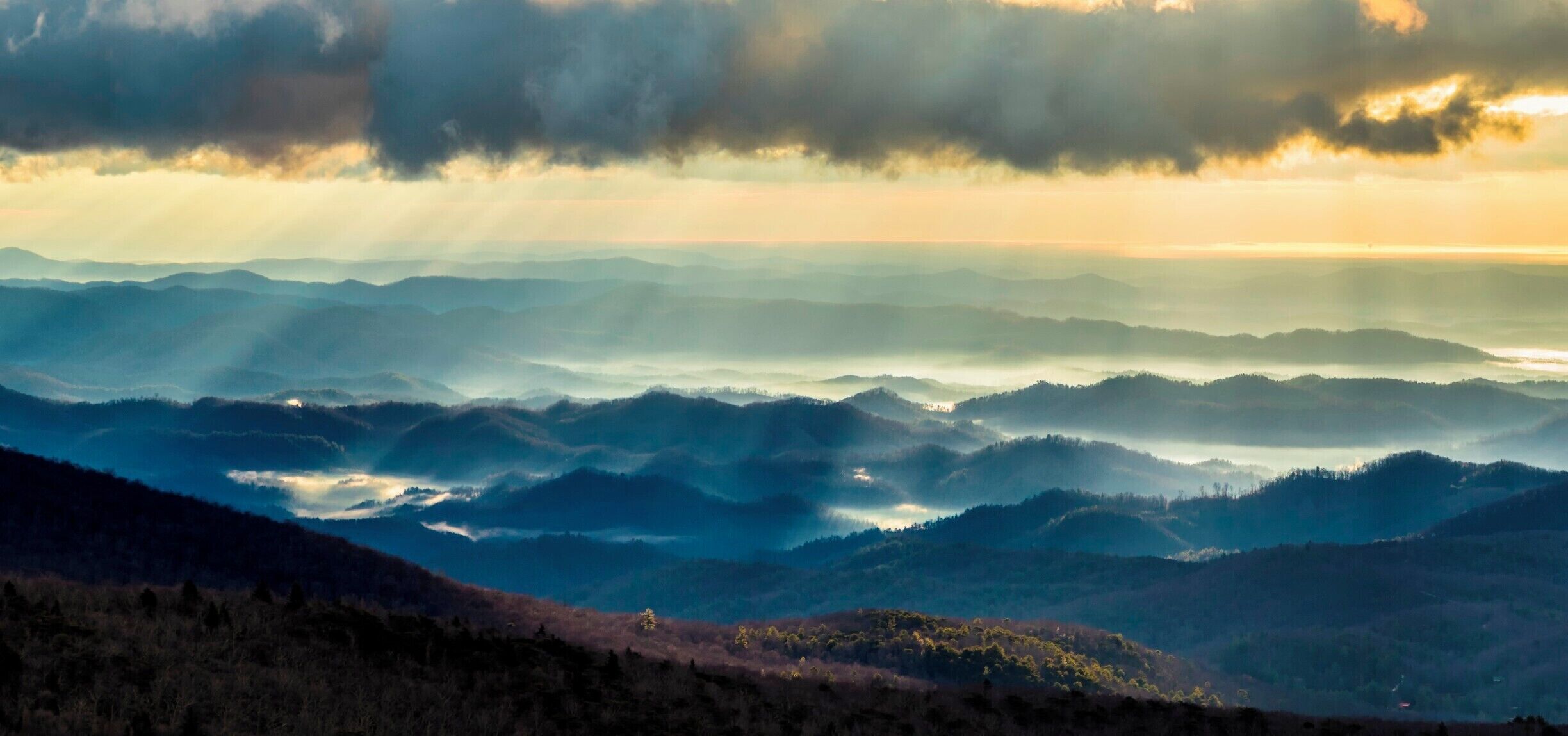 A telephoto view of the foothills from Linn Cove Viaduct. I really loved the fog moving through and the sun rays. 