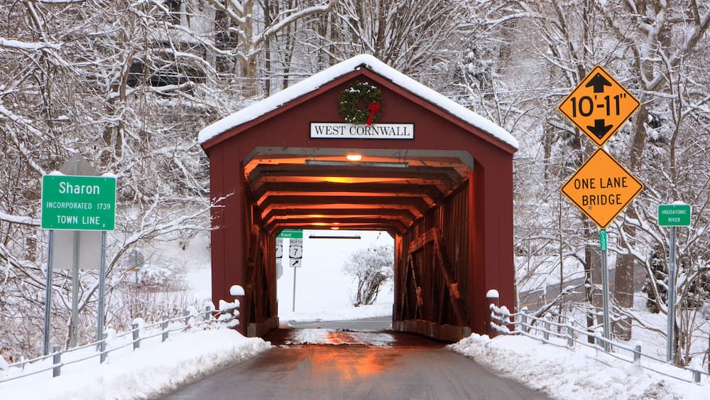 Covered bridge with a Christmas wreath in winter in West Cornwall, Connecticut