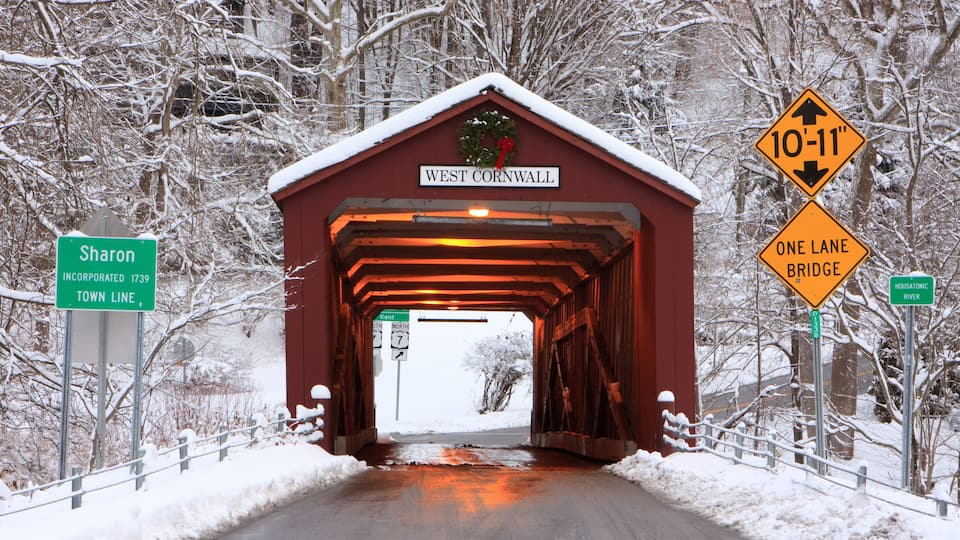 A covered bridge with a sign reading 'West Cornwall' and a '10'-11' height clearance warning.