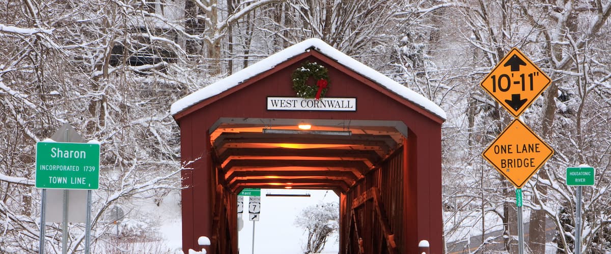 A covered bridge with a sign reading 'West Cornwall' and a '10'-11' height clearance warning.
