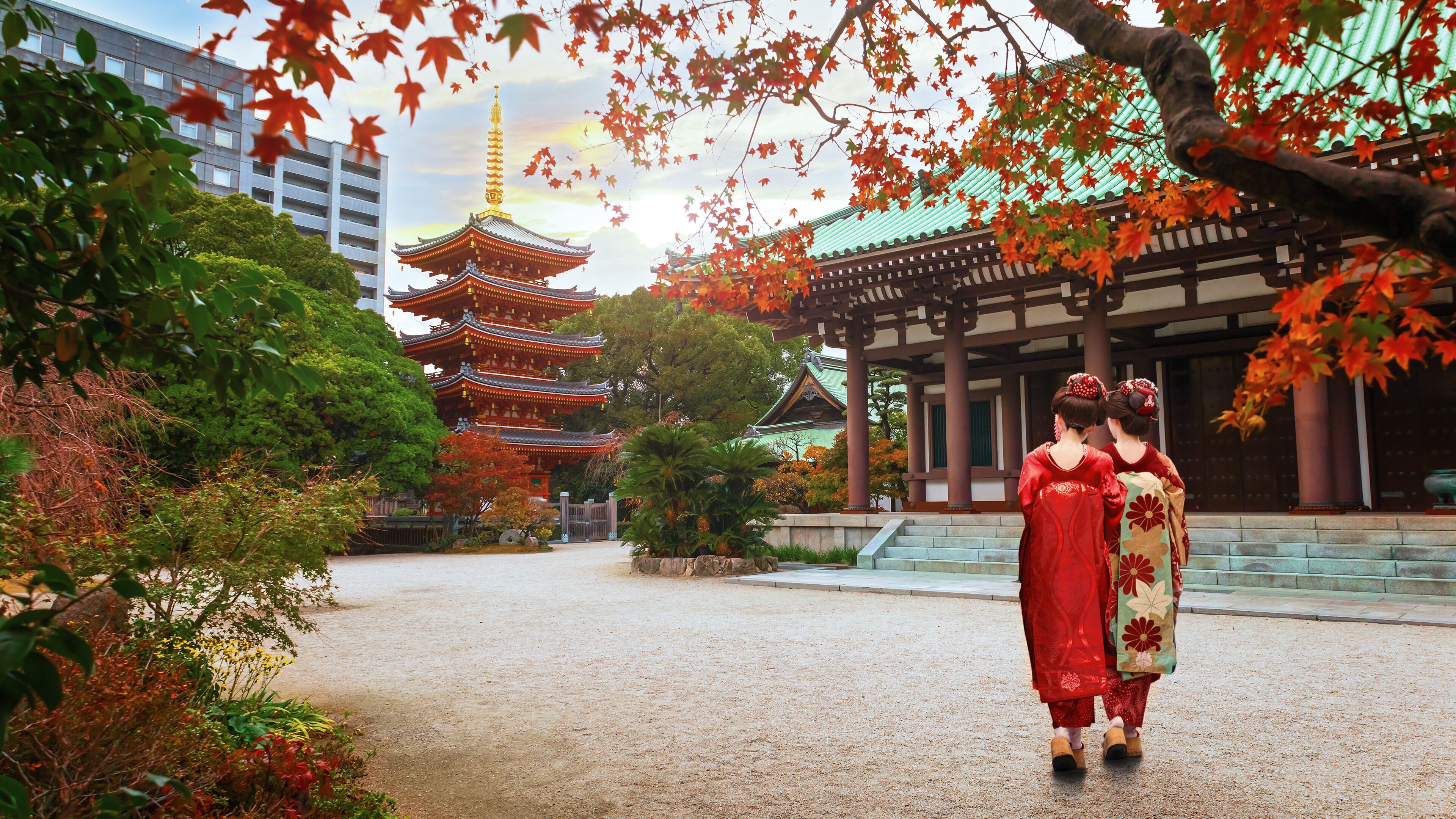 A traditional Japanese temple with a multi-tiered pagoda, surrounded by autumn foliage and traditional architecture.