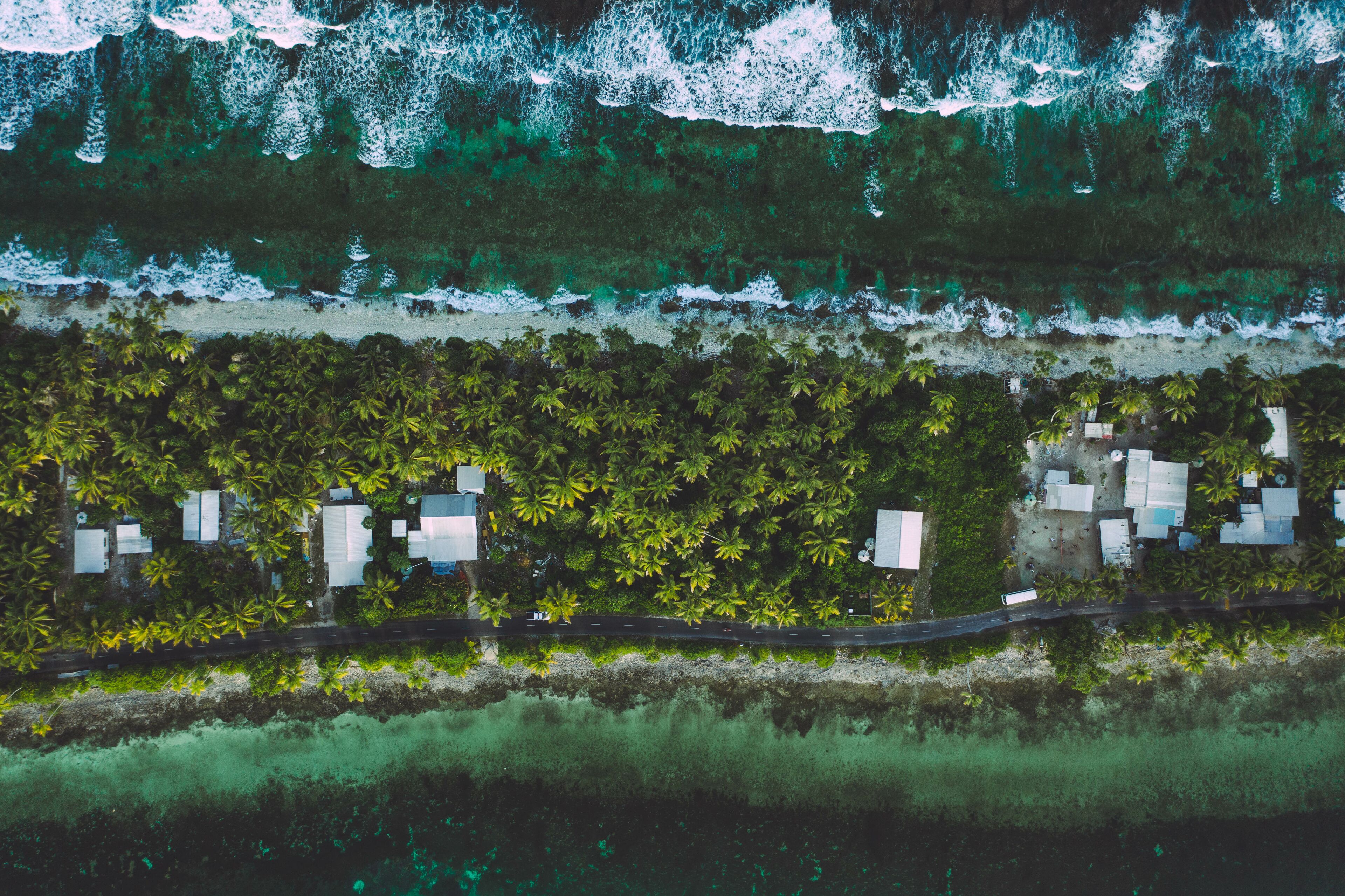 Tuvalu (Funafuti) aerial shot of one of the thinest part of the island where the ocean and lagoon can be seen together .