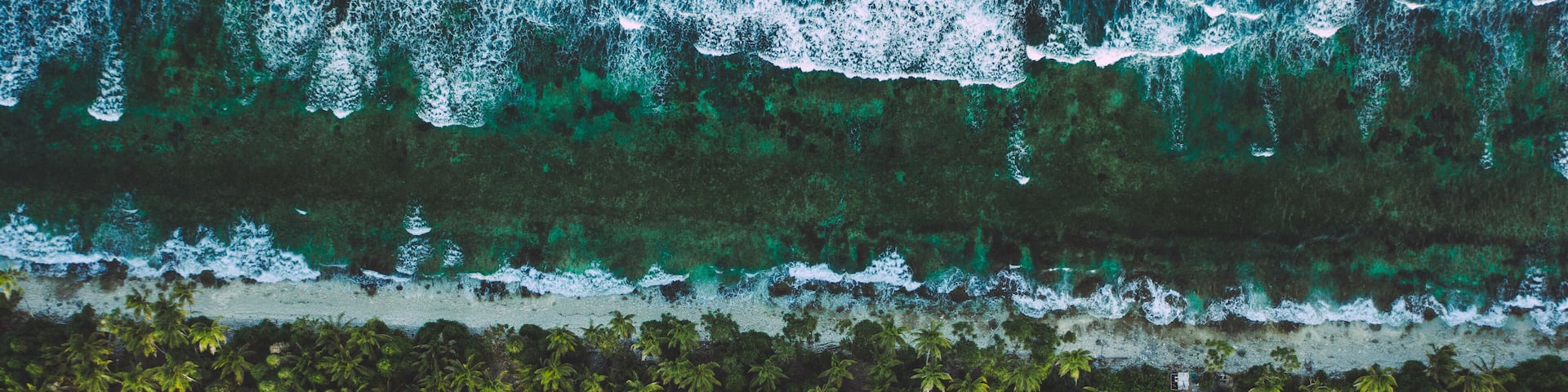 Tuvalu (Funafuti) aerial shot of one of the thinest part of the island where the ocean and lagoon can be seen together .