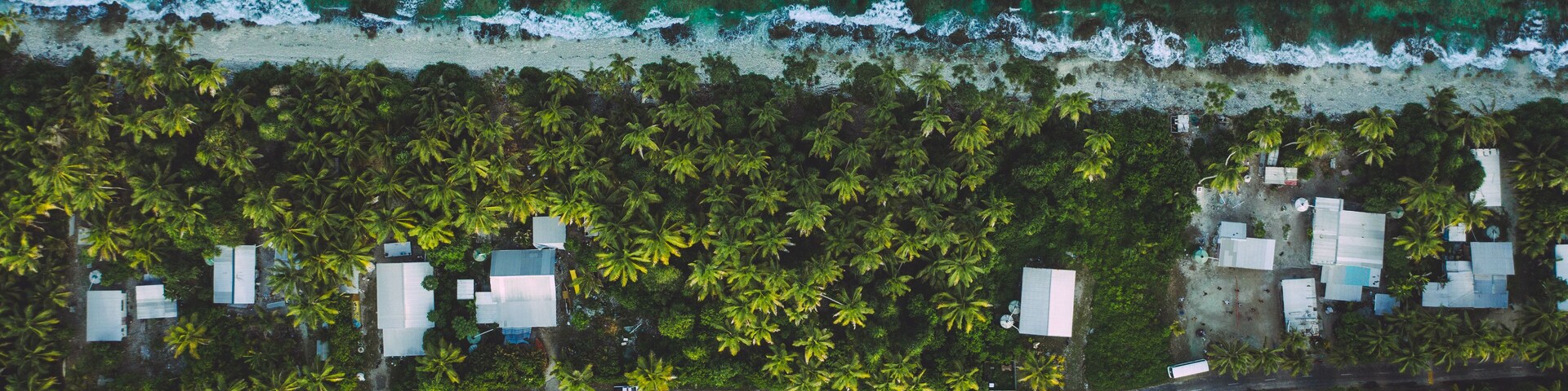 Tuvalu (Funafuti) aerial shot of one of the thinest part of the island where the ocean and lagoon can be seen together .